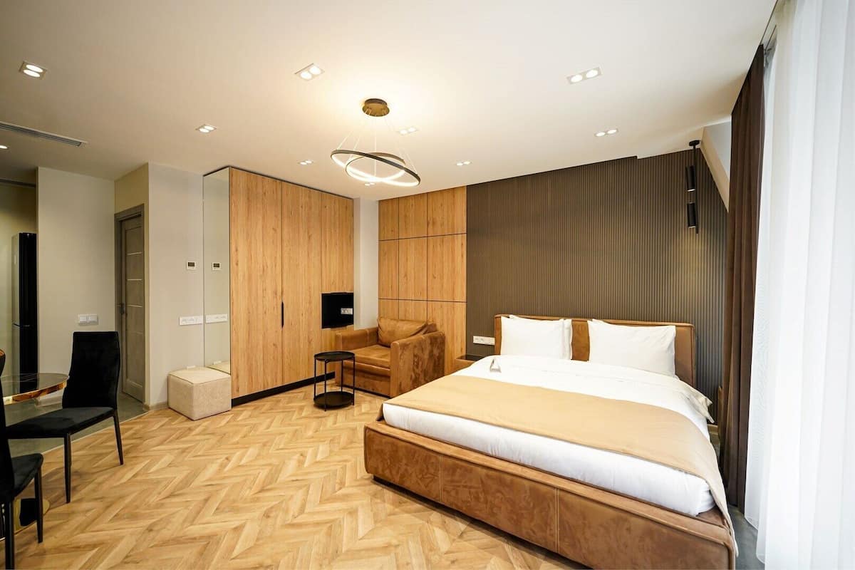Una habitación de hotel moderna con una cama grande, un escritorio y una zona de estar.