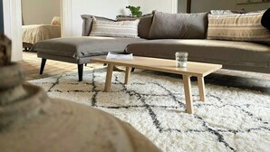 A living room with a sofa, ottoman, and a coffee table. - Peaceful cottage near Saint-Savin Abbey (Journet)