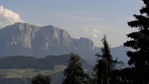 Un paisaje montañoso con cielo despejado, una piscina y una estructura de madera.