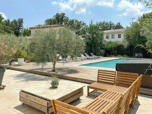 Ein Poolbereich mit Liegestühlen, einem kleinen Schwimmbecken und einer Holzterrasse.