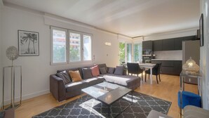 Ein modernes Wohnzimmer mit einer Couch, einem Couchtisch und einem Essbereich mit Stühlen.