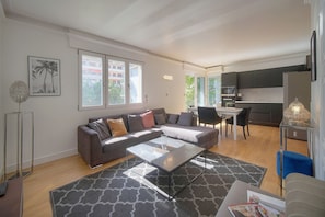 Ein modernes Wohnzimmer mit einer Couch, einem Couchtisch und einem Essbereich mit Stühlen.