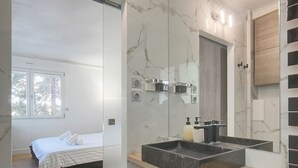 Ein modernes Badezimmer mit einem großen Spiegel, zwei Waschbecken und einer hölzernen Sitzbank.