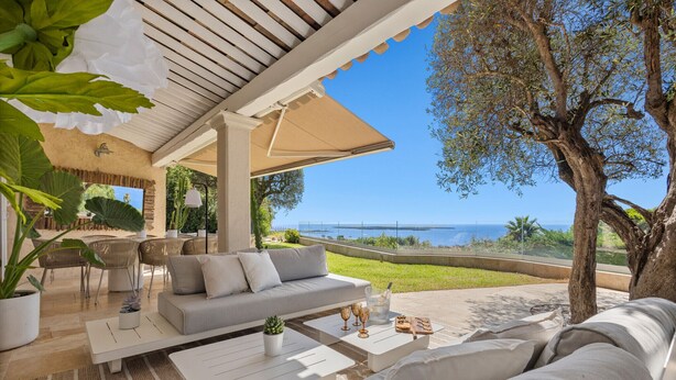 A covered outdoor seating area with a sofa, coffee table, and potted plants. - FRGK Luxury Sea View Villa ANITA Heated Pool 7 Bed (Cannes)