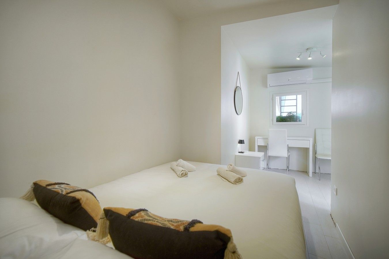 Een hotelkamer met een bed, bureau en stoel.