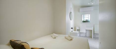 Een hotelkamer met een bed, bureau en stoel.