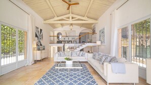 A spacious living area with a high ceiling, a staircase, and large windows. - FRGK Villa Mare Moure Rouge Palm Beach (Cannes)