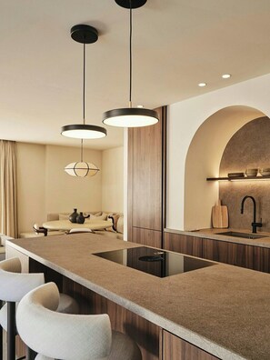 A modern kitchen with a central island, pendant lighting, and a built-in sink. - Villa with rooftop terrace near beach in Marbella (Marbella)