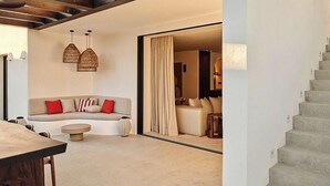 A modern living room with a sofa, a dining table, and hanging pendant lights. - Villa with rooftop terrace near beach in Marbella (Marbella)
