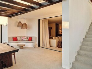 A modern living room with a sofa, a dining table, and hanging pendant lights. - Villa with rooftop terrace near beach in Marbella (Marbella)
