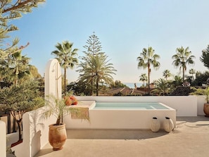 A rooftop pool with a view of palm trees and a distant coastline. - Villa with rooftop terrace near beach in Marbella (Marbella)
