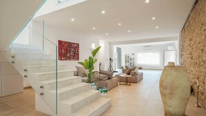 A modern interior with a staircase, a large vase, and a sofa. - Historic villa overlooking Scopello sea stacks (Castellammare del Golfo)