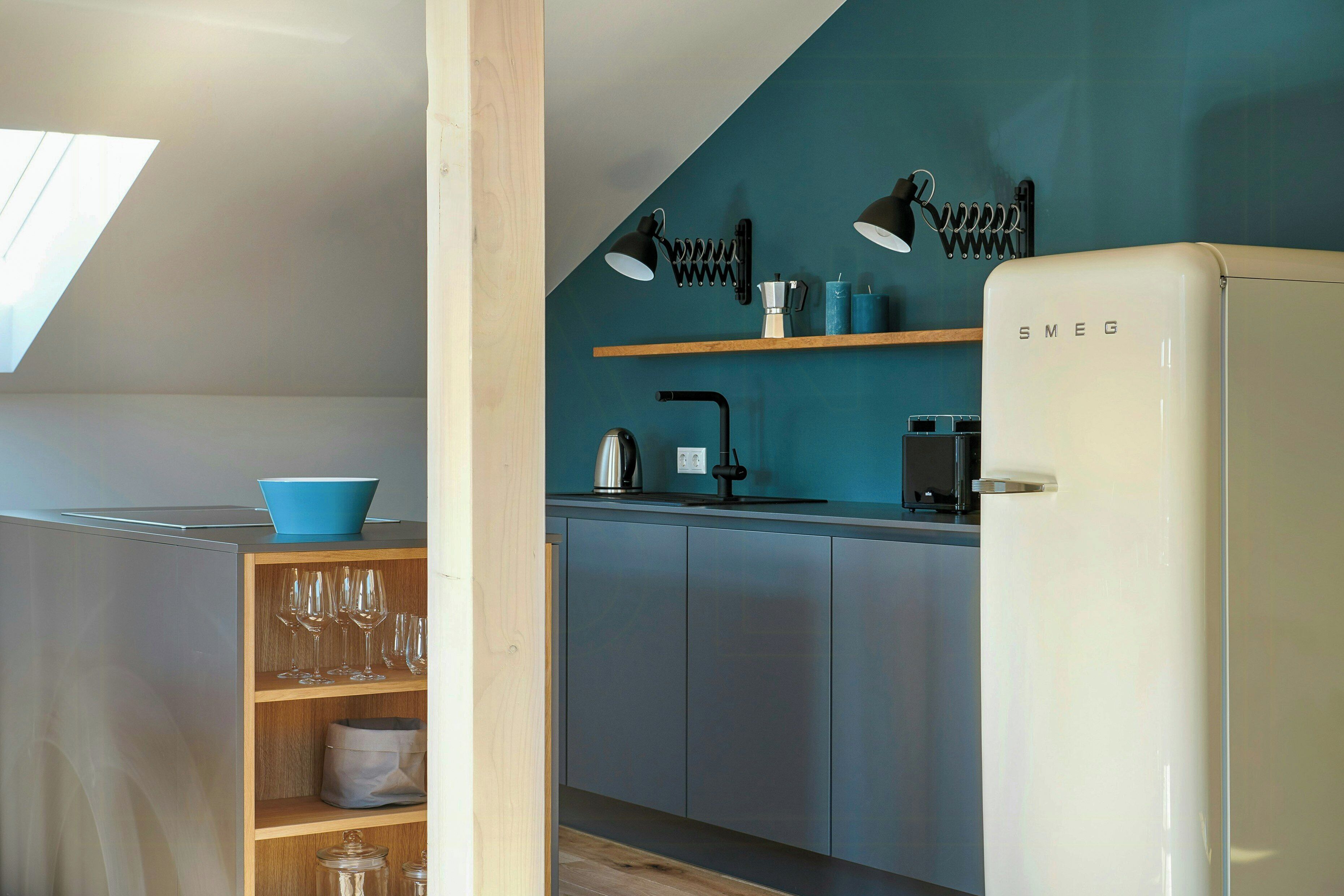 Una cocina moderna con tragaluz, un refrigerador blanco y estantes de madera.
