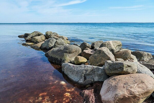 Eine felsige Küstenlinie mit klarem Wasser und weiter Ferne.