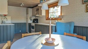 Una cocina con una mesa redonda, una silla azul y una ventana con vistas.