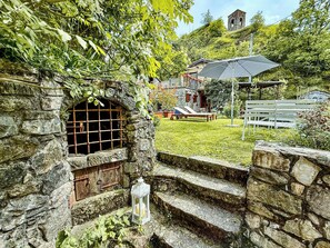 A stone staircase leading to a stone building with a window and a lantern. - Nature retreat in Garfagnana (San Romano in Garfagnana)