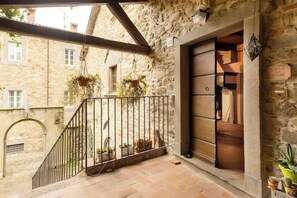A stone building with a metal railing, potted plants, and a wooden door labeled 'CASA DE CIAN.' - Nature retreat in Garfagnana (San Romano in Garfagnana)