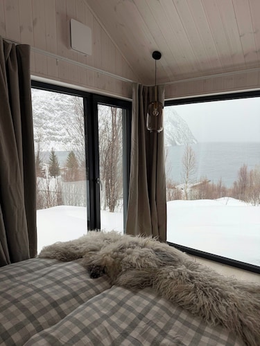Northern lights cabin in Lyngen Alps by fjord