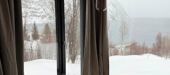 Northern lights cabin in Lyngen Alps by fjord
