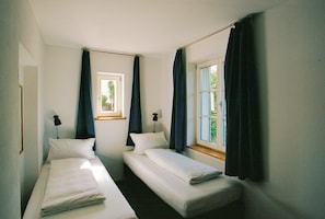 A twin room with two single beds, a window, and a door. - Riverside Studio with Garden Views (Werder (Havel))