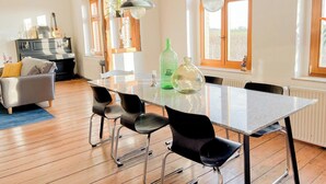 A modern kitchen with a dining table, chairs, and a hanging light fixture.