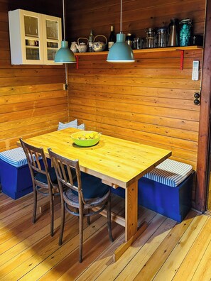 A wooden interior with a table, chairs, a bench, and a cabinet. - Family house by Marielyst beach with large garden (Væggerløse)