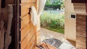 A wooden door with a towel hanging on it, leading to a garden area with a stone bench and a small table. - Historic village with pool near Todi (Todi)