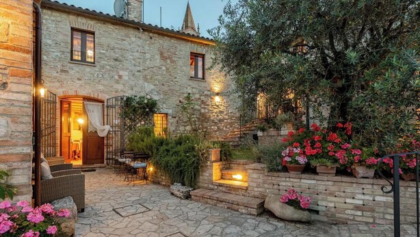 A stone building with a courtyard, outdoor seating, and potted plants. - Historic village with pool near Todi (Todi)