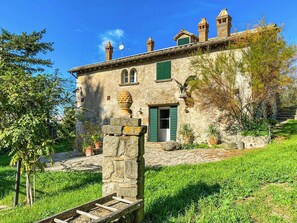 A stone building with a green door, a small window, and a stone staircase leading to the entrance. - Farmhouse with pool amid ancient oaks in Tuscia (Viterbo)