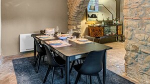 A dining area with a stone archway, a table set for four, and a mirror reflecting the room. - Farmhouse with pool amid ancient oaks in Tuscia (Viterbo)