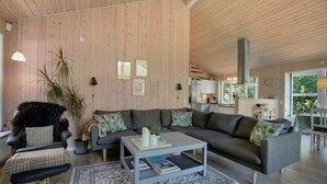 En hyggelig stue med sofa, sofabord og et spiseområde med bord og stole.