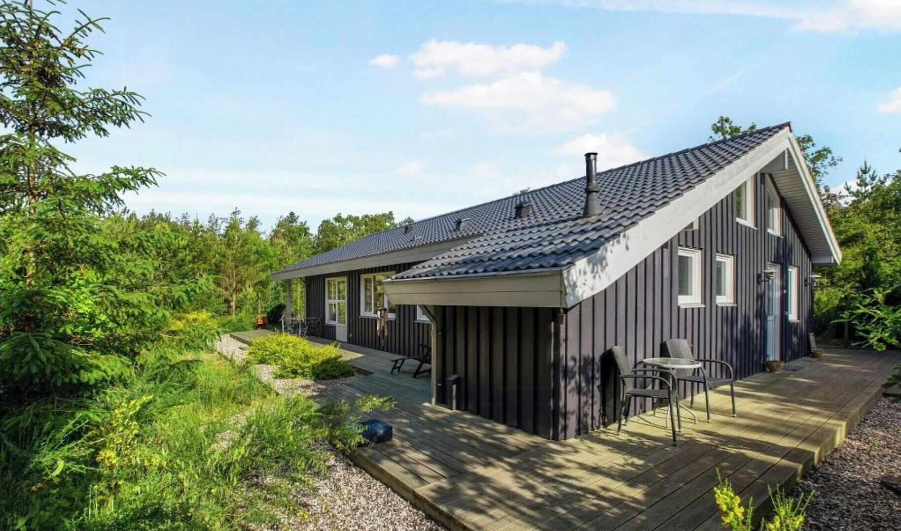 A modern house with a sloped roof, a covered porch, and a deck.