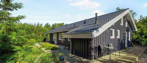 A modern house with a sloped roof, a covered porch, and a deck.