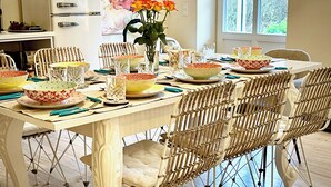 Ein Esstisch, reich gedeckt mit Schüsseln, Gläsern und einer Blumenvase.