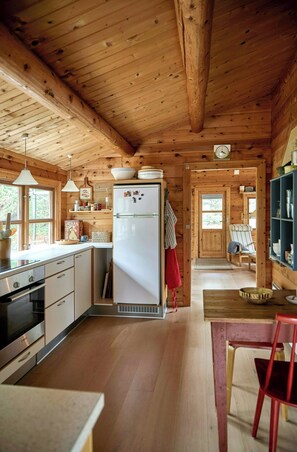 A wooden cabin interior with a kitchen, dining area, and a cozy living space. - Cozy gem near Tversted Plantage (Aalbæk)