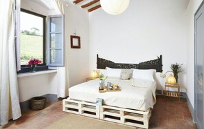 A bedroom with a bed, bedside tables, a window with curtains, a wooden headboard, and a view of the outdoors. - Rustic villa with pool in the heart of Chianti (San Casciano in Val di Pesa)