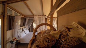 A room with a bed, a small table with fruit, and a basket of items. - Glamping Podere San Jacopo (Massa Marittima)