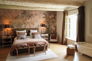 A bedroom with a bed, nightstands, a lamp, a chair, a window, and a bathtub. - 19th-century mas with pool and garden (Oppède)