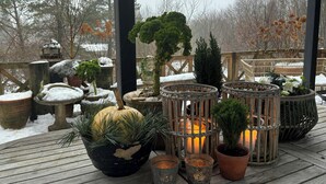 A wooden deck with potted plants and candles. - Step through the gate and feel peace in the woods (Silkeborg)