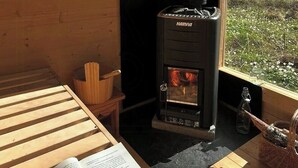 A Harvia wood stove in a wooden cabin with a view of a lake. - Rustic cottage for creative souls by Lake Lingbo (Lingbo)