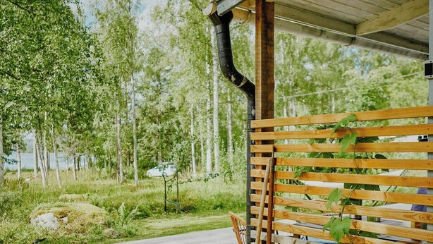 A wooden bench with a metal frame, a concrete pathway, and a grassy area with trees. - Rustic cottage for creative souls by Lake Lingbo (Lingbo)