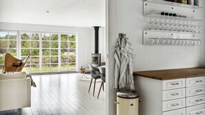 A modern interior with a fireplace, dining area, and wine rack.