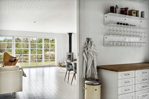 Een modern interieur met een open haard, een eethoek en een wijnrek.