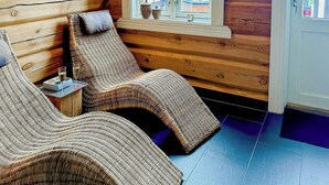 A log cabin room with a window, wicker furniture, and a view of the outside.