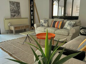 Ein Wohnzimmer mit Sofa, Couchtisch und einer dekorativen Vase.