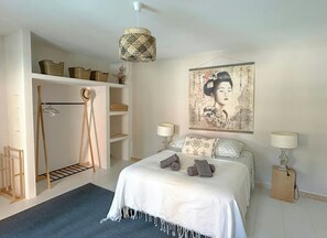 Ein Schlafzimmer mit einem Bett, zwei Nachttischlampen, einer Deckenleuchte, einem Kleiderschrank und einem an der Wand hängenden Gemälde.