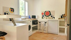 Una cocina equipada con lavadora, microondas y lavabo.