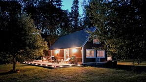 Una casa con portico, barbecue e una piccola terrazza.