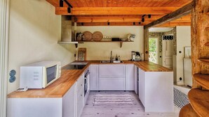 Una cucina compatta con forno a microonde, lavello e piano di lavoro in legno.