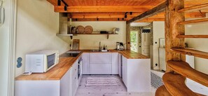 A compact kitchen with a microwave, sink, and wooden countertop. - Cottage by the stream in southern Halland (Laholm)